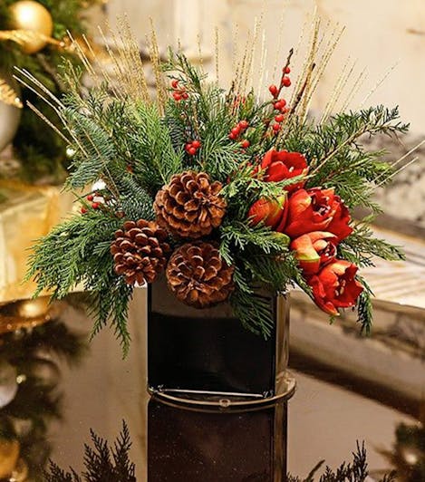 A winter-themed bouquet, accented with holly and pine cones