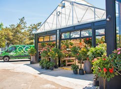 A QG Floral + Landscape van parks just outside the open garage doors of our greenhouse