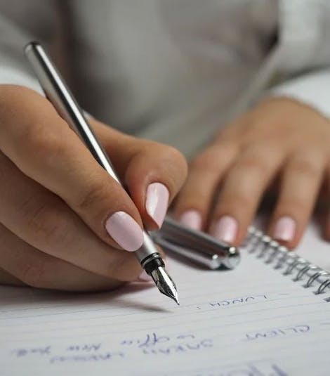 Close-up of a woman's hands taking notes